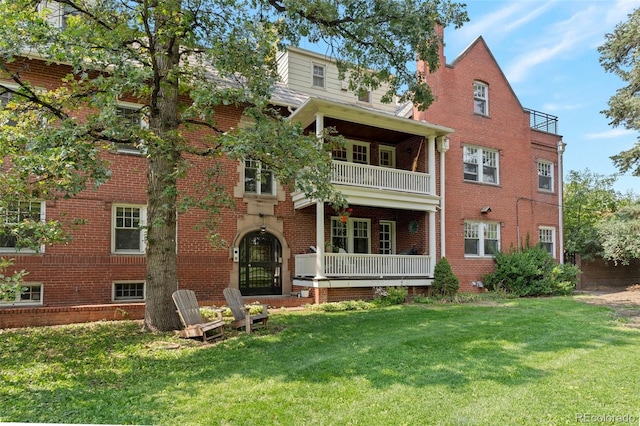 back of house featuring a balcony, french doors, and a yard