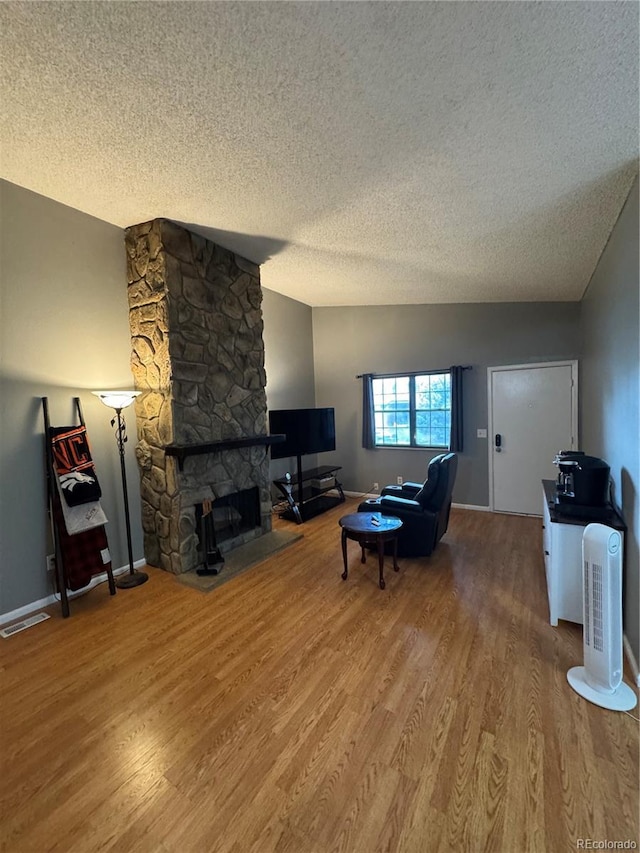 7020 W Portland Ave, Littleton, CO 80128 - living room featuring a textured ceiling, wood finished floors, and a fireplace