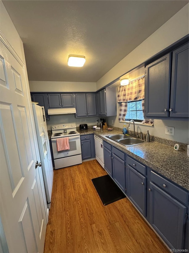 7020 W Portland Ave, Littleton, CO 80128 - kitchen featuring white appliances, under cabinet range hood, light wood finished floors, a textured ceiling, and blue cabinetry