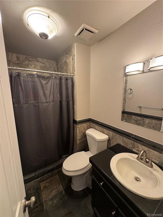 7020 W Portland Ave, Littleton, CO 80128 - bathroom with tile walls, vanity, a wainscoted wall, and a shower with shower curtain