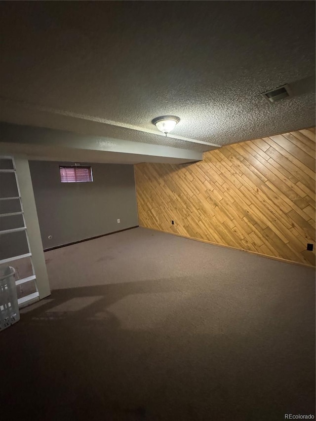 7020 W Portland Ave, Littleton, CO 80128 - finished basement with carpet floors, a textured ceiling, and wood walls