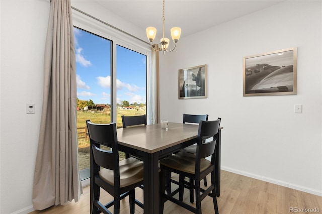 dining room featuring light hardwood / wood-style flooring and a chandelier