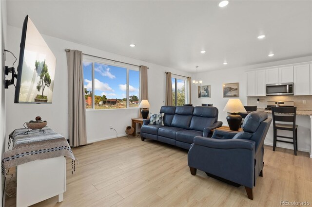 living room featuring a notable chandelier and light hardwood / wood-style flooring