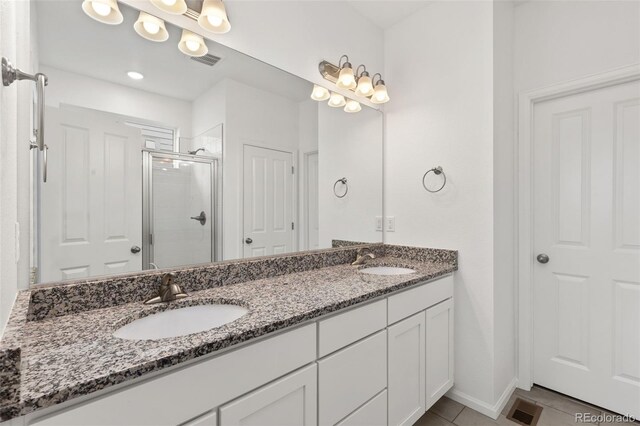 bathroom featuring walk in shower, tile patterned floors, and vanity