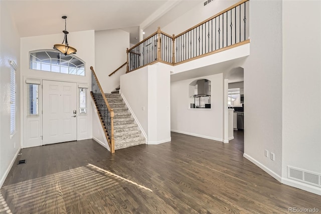 foyer entrance featuring a high ceiling and dark hardwood / wood-style floors