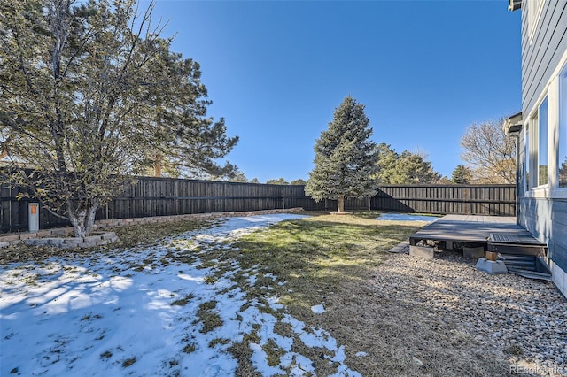 yard covered in snow with a wooden deck