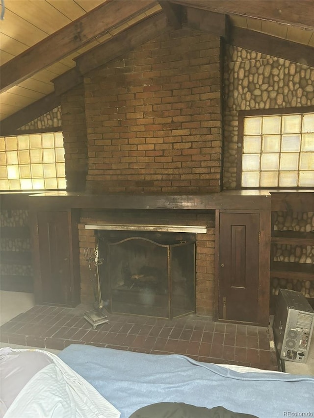 interior details featuring beamed ceiling, a brick fireplace, and wooden ceiling