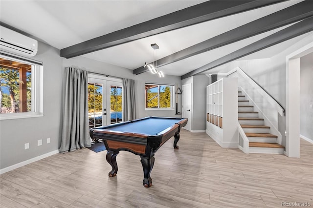 recreation room featuring light wood-style flooring, french doors, beamed ceiling, and an AC wall unit