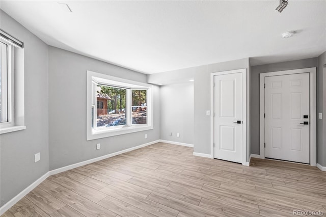 unfurnished bedroom with light wood-type flooring and baseboards