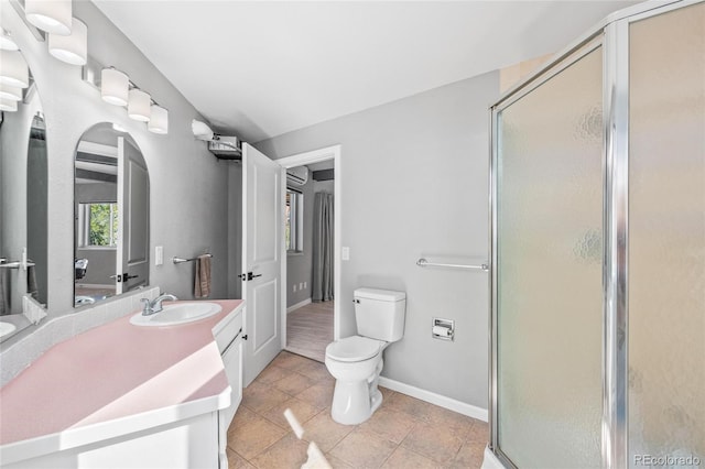 bathroom with toilet, a stall shower, vanity, baseboards, and tile patterned floors