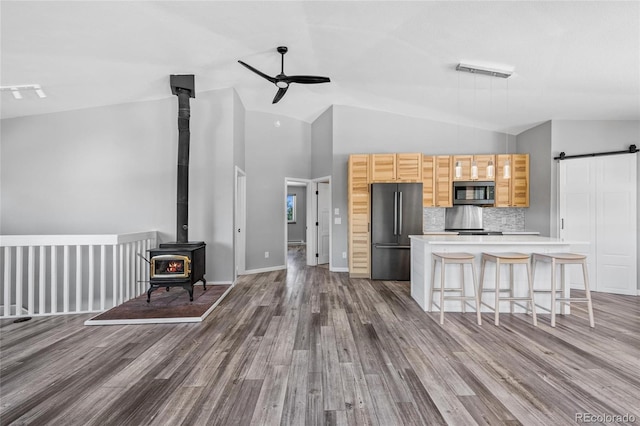 kitchen with dark wood finished floors, visible vents, a barn door, appliances with stainless steel finishes, and ceiling fan