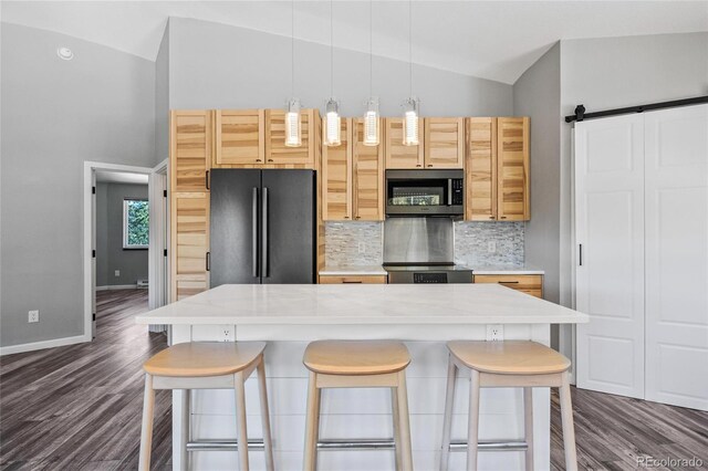 kitchen with lofted ceiling, light countertops, stainless steel microwave, backsplash, and freestanding refrigerator