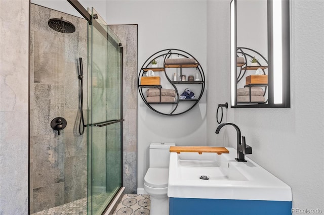 bathroom with toilet, a stall shower, and vanity