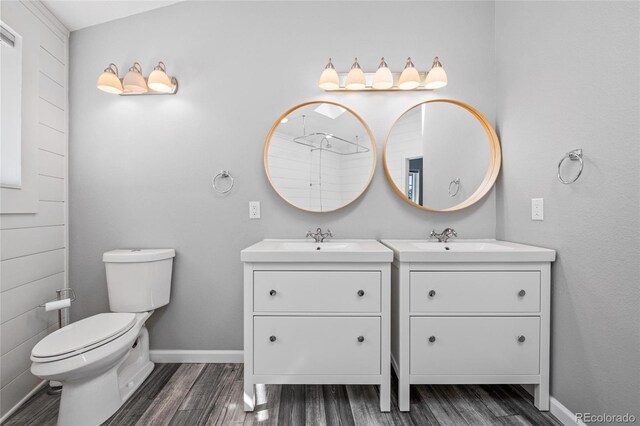 bathroom with two vanities, a sink, and wood finished floors