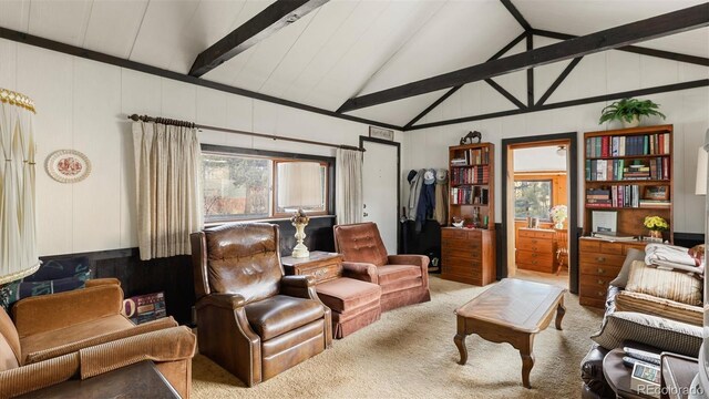 carpeted living room featuring vaulted ceiling with beams