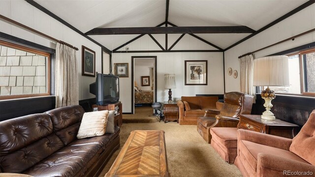 carpeted living room featuring lofted ceiling with beams