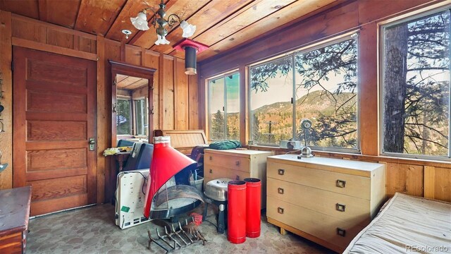 interior space with wooden walls, a mountain view, and wood ceiling