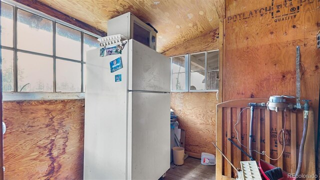 kitchen with wood walls, plenty of natural light, and white refrigerator