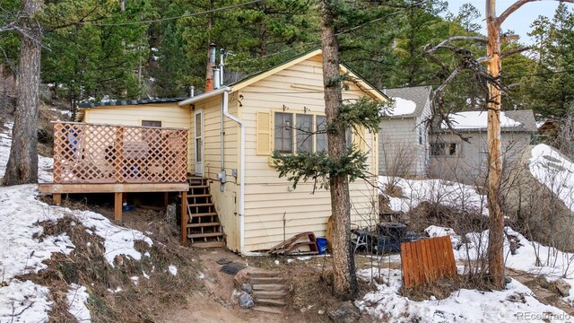 view of snow covered back of property