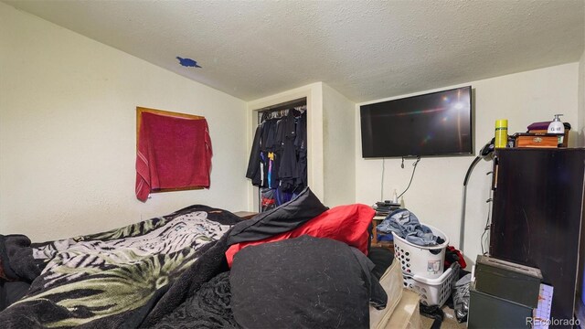 bedroom featuring a textured ceiling, a closet, and lofted ceiling