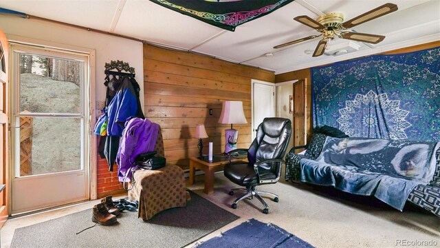 bedroom with carpet flooring, ceiling fan, and wood walls