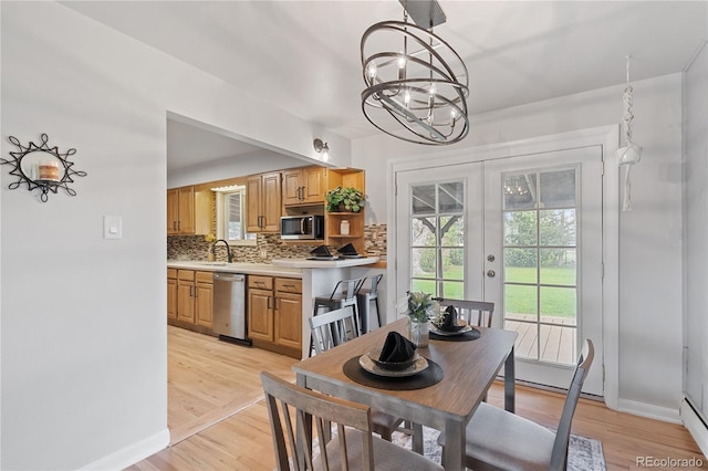865 S Everett St, Lakewood, CO 80226 - dining area with baseboards, light wood-style flooring, a chandelier, and french doors
