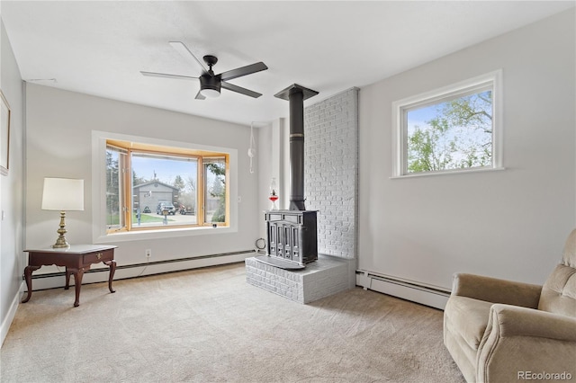 865 S Everett St, Lakewood, CO 80226 - living room featuring a baseboard radiator, a wood stove, carpet flooring, and ceiling fan
