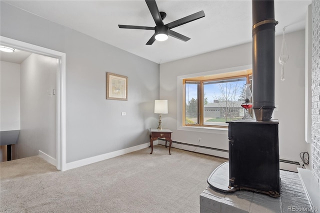 865 S Everett St, Lakewood, CO 80226 - sitting room featuring a baseboard radiator, carpet, ceiling fan, and a wood stove