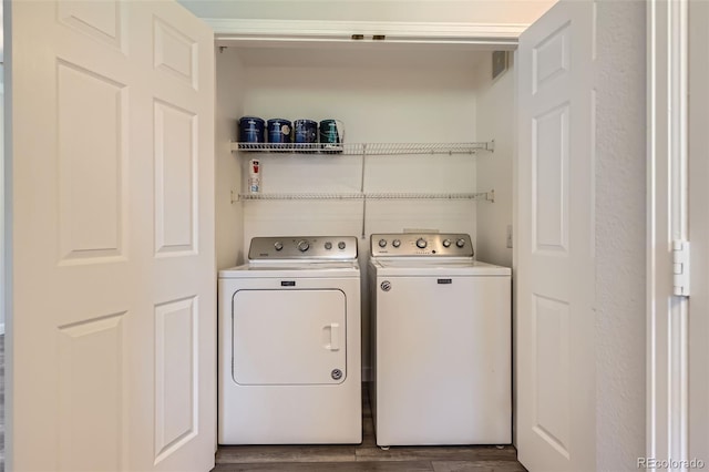 laundry room featuring washer and dryer and dark wood finished floors