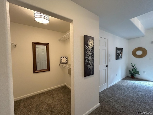 corridor with baseboards and carpet flooring