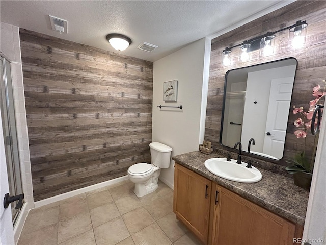 bathroom featuring visible vents, wood walls, and a textured ceiling