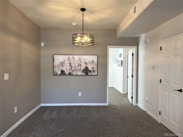 unfurnished dining area featuring dark carpet, visible vents, and baseboards