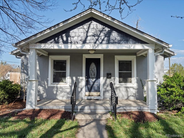 bungalow-style home featuring stucco siding and a porch