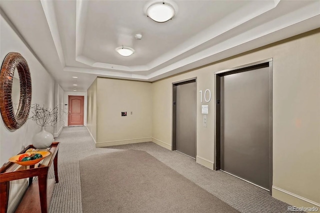 300 W 11th Ave Unit 10D, Denver, CO 80204 - hall featuring a tray ceiling, light carpet, baseboards, and elevator