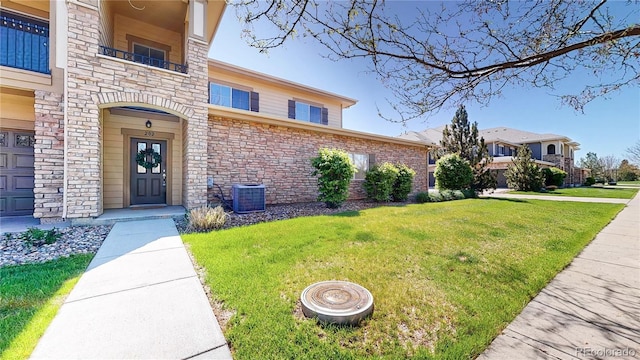 11374 Xavier Dr Unit 202, Westminster, CO 80031 - entrance to property with stone siding, a yard, and central air condition unit