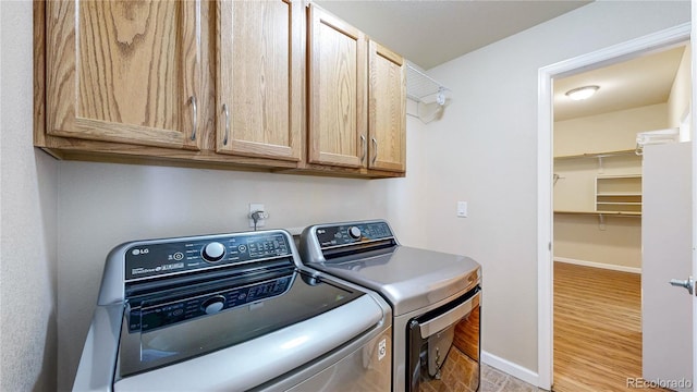 11374 Xavier Dr Unit 202, Westminster, CO 80031 - washroom featuring separate washer and dryer, cabinet space, baseboards, and wood finished floors