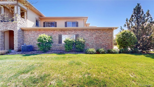 11374 Xavier Dr Unit 202, Westminster, CO 80031 - view of home's exterior featuring central AC unit, a yard, and stone siding