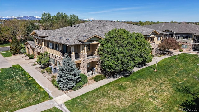 11374 Xavier Dr Unit 202, Westminster, CO 80031 - view of side of home featuring stone siding, a balcony, a lawn, and cooling unit