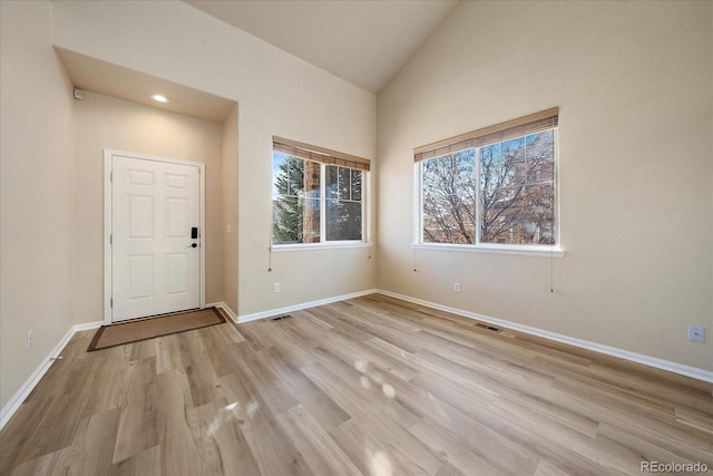 foyer with vaulted ceiling and light hardwood / wood-style floors