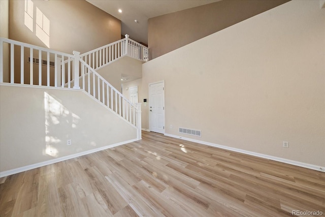 interior space featuring a high ceiling and light hardwood / wood-style flooring