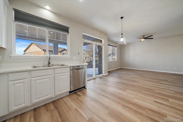 kitchen with light hardwood / wood-style floors, dishwasher, white cabinetry, sink, and pendant lighting