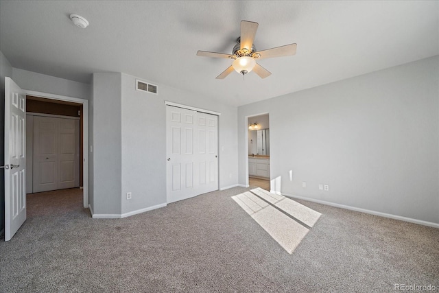 unfurnished bedroom with a closet, ceiling fan, carpet flooring, and ensuite bath