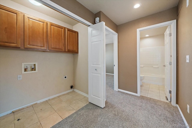 washroom with washer hookup, cabinets, light tile patterned floors, and electric dryer hookup