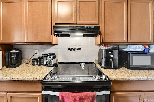 kitchen with decorative backsplash, light stone countertops, and stainless steel range with electric cooktop