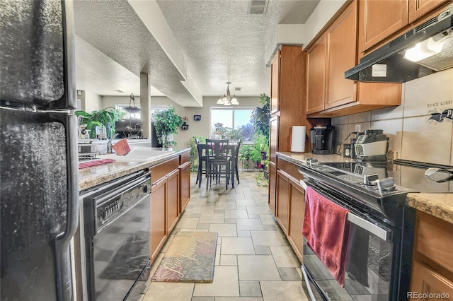 kitchen with hanging light fixtures, backsplash, a textured ceiling, black appliances, and sink