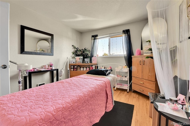 bedroom featuring hardwood / wood-style floors and a textured ceiling