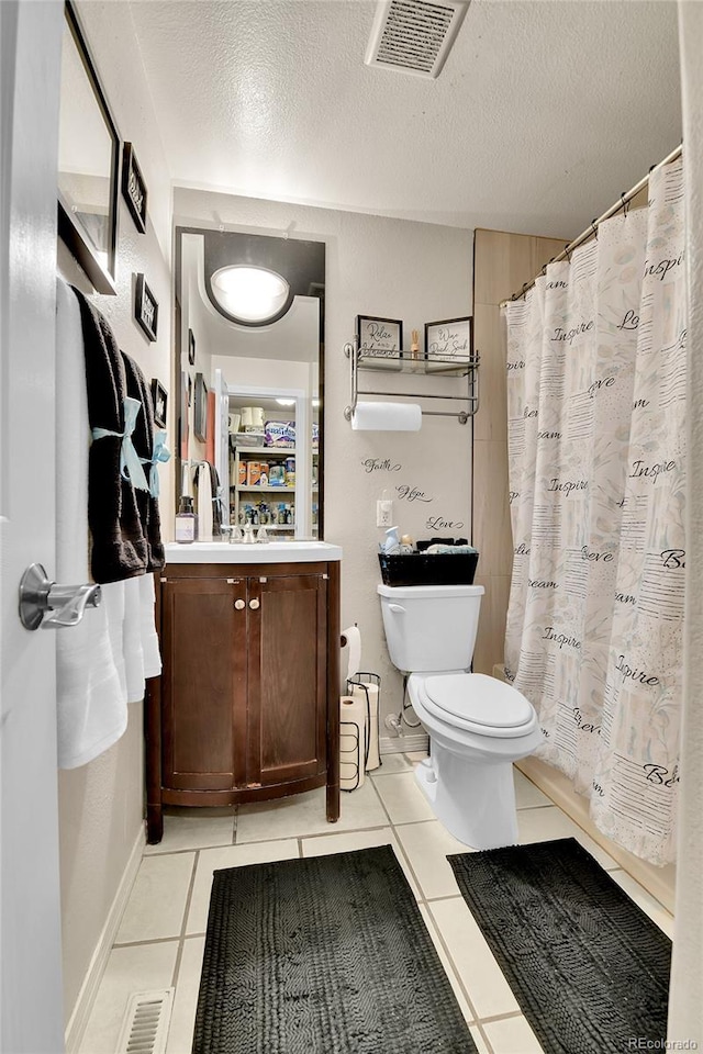 bathroom with vanity, a textured ceiling, toilet, and tile patterned flooring