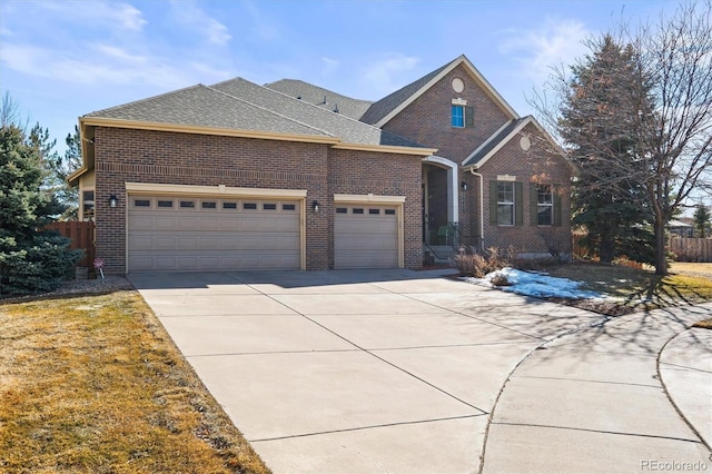 traditional-style home with a garage, brick siding, a shingled roof, fence, and driveway