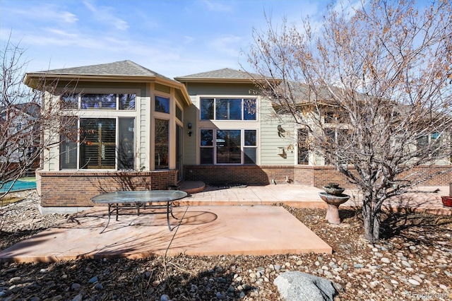 rear view of house featuring a patio area and brick siding