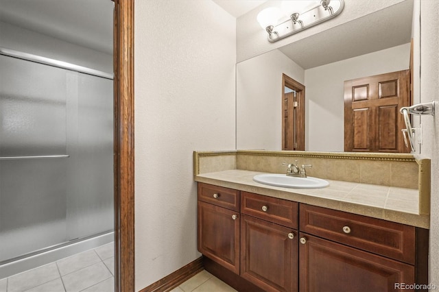 bathroom featuring a shower stall, vanity, tasteful backsplash, and tile patterned floors